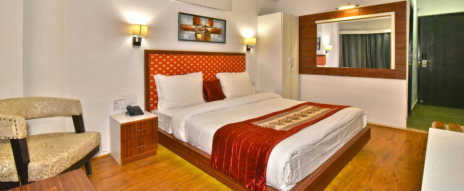 Side view of the bedroom with two warm lights on each side at DLS Hillcrest Resort, Shimla.